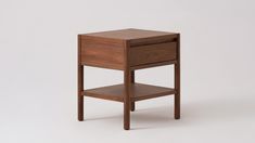 a small wooden table with one drawer on the top and two shelves below it, against a white background