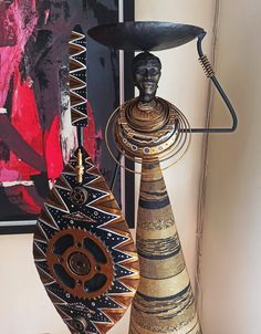 two vases sitting on top of a table next to a wall mounted art piece