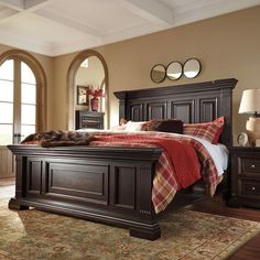 a large bed sitting in a bedroom on top of a wooden floor next to a window