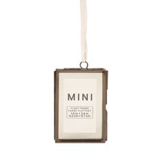 an ornament hanging from a string with the word mini in it's center