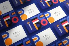 many business cards are stacked on top of each other with different colors and shapes in them