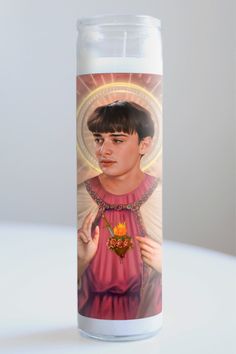 a candle with an image of a young man on the front and back of it