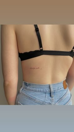 the back of a woman's bra showing her small tattoo on her left side