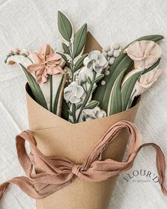 a bouquet of flowers is wrapped in brown paper