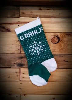 a green and white christmas stocking with the word g rhlf on it