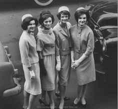 black and white photograph of four women standing in front of an airplane