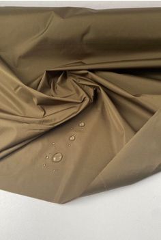 Khaki Tone- Waterproof Twill Fabric. Haute Couture French Designer Brand.  This weighty fabric has a luxurious feel and drape. It is a non-stretch type and fully waterproof, ideal for raincoats and trench coats. It comes directly from the design house of a very famous luxury French designer brand.  Composition: Polyamide Density- 140.00 g/m² Width- 145.00 cm Purpose- Raincoat, Trench Coat Weaving- Twill Stretch- Non-stretch Color- Shade of green All fabrics are portrayed in a natural light. If you require additional images and videos, please message us. Trench Coat Fabric, Waterproof Khaki Nylon Raincoat, Khaki Nylon Waterproof Raincoat, Khaki Waterproof Nylon Raincoat, Solid Waterproof Raincoat, Fabric Texture Material Fashion Textiles, Waterproof Khaki Raincoat For Rainy Weather, Types Of Clothes Fabrics, Raincoat Trench