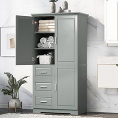 a bathroom cabinet with towels and other items on it in front of a marble wall