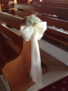 a bouquet of baby's breath sits on the pews at a church wedding