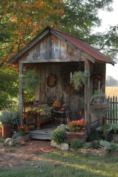 a small wooden shed with potted plants in it