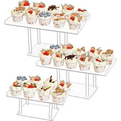 three tiered trays filled with cupcakes and fruit