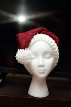 "Crochet Santa hat in ivory and cranberry. Created using the Red Heart pattern.  Size large (adult)  Hat circumference approx 20\" stretches to 23\".  Made using 100% Acrylic yarn (Hobby Lobby I Love this Yarn)  Machine wash cold, lay flat to dry.  If you have any questions feel free to ask. Matching Christmas Stocking coming soon." Red Adjustable Christmas Hat, Adjustable Red Christmas Hat, Winter White Crochet Hat As Gift, White Crochet Hat For Winter Gift, Red Hat As A Gift, One Size Fits All, Adjustable Red Hats For Holiday, Adjustable Red Hat For Holiday, Red Hat As A Gift, White Christmas Hat As Gift