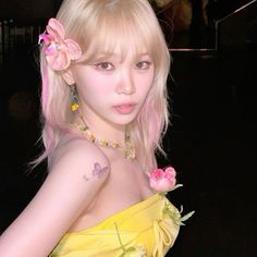 a young woman with pink hair and flowers in her hair, wearing a yellow dress