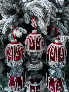 three red and white ornaments hanging from a tree