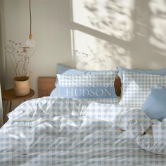 a bed with gingham sheets and blue pillows