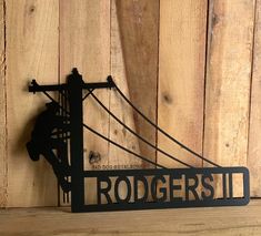 a metal sign that reads,'rodeorside'hanging from the side of a wooden wall