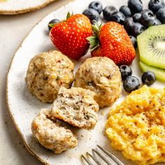 a white plate topped with fruit and muffins