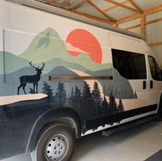 a van painted with an image of a deer on it's side and mountains in the background