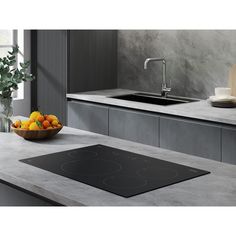 a bowl of fruit sitting on top of a counter next to a sink and stove