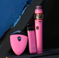 a pink electronic device sitting next to a blue wall