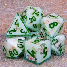 a set of seven dice with numbers and flowers on the sides, sitting on a table