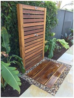 a wooden bench sitting in the middle of a garden next to a tall planter