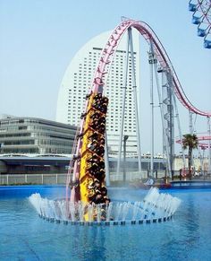 several people ride on a roller coaster in an amusement park with water splashing behind them