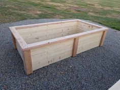 a wooden planter box sitting on top of gravel