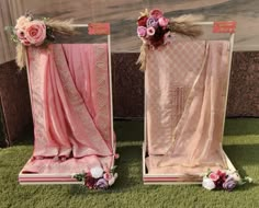 two pink and gold decorated chairs sitting on top of green grass