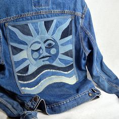 a blue jean jacket with the sun painted on it