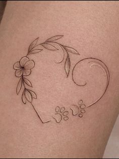 a small tattoo on the side of a woman's thigh with flowers and leaves