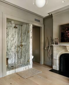 a bathroom with a fireplace and marble shower