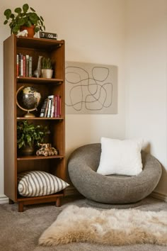 a living room with a chair, bookshelf and rug