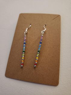 A pair of handmade rainbow drop earrings, ready to add a splash of color. Adjustable Rainbow Earrings As Gift, Hypoallergenic Multicolor Sterling Silver Earrings, Colorful Hypoallergenic Dangle Jewelry, Nickel-free Rainbow Round Beaded Earrings, Rainbow Drop Earrings As A Gift, Nickel-free Rainbow Earrings Gift, Nickel-free Rainbow Earrings For Gift, Rainbow Nickel-free Earrings For Gifts, Rainbow Hypoallergenic Earrings As Gift