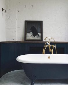 an old fashioned bathtub in front of a painting on the wall