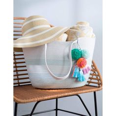 a large white bag sitting on top of a wicker chair next to a hat