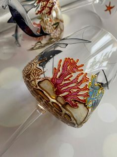 two wine glasses sitting on top of a table next to each other with different designs