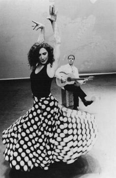 a woman in a polka dot dress holding a guitar