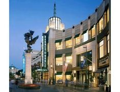 a large building with a statue in the middle of it's front yard at night