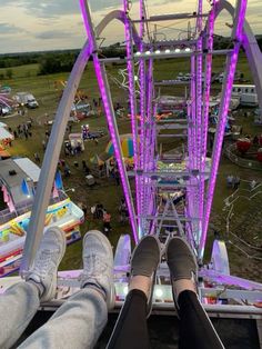 someone is sitting in the middle of a ferris wheel at an amusement park with their feet up