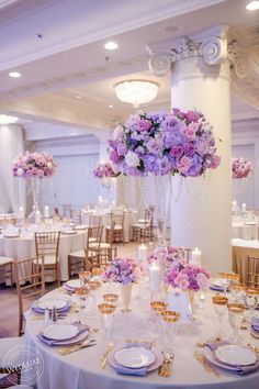 the tables are set with purple and white flowers