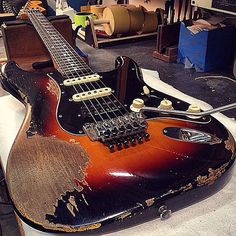 an old guitar sitting on top of a table