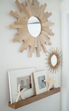 a sunburst is hanging on the wall above a shelf with pictures and frames