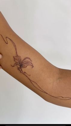 a woman's arm with a flower tattoo on the left side of her arm