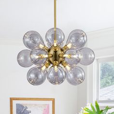 a chandelier hanging from the ceiling in a room with white walls and windows