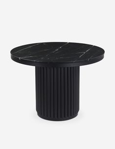 a round table with black marble top on a white background in the style of art deco