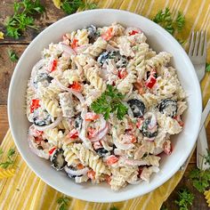 a white bowl filled with pasta salad on top of a table