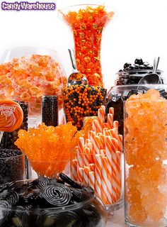 many different types of candies and candy in glass vases on a white table