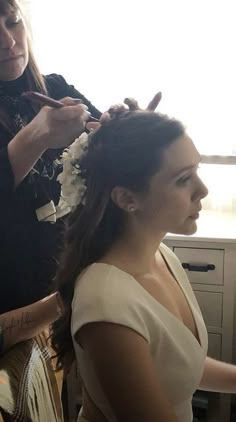 a woman getting her hair done by another woman