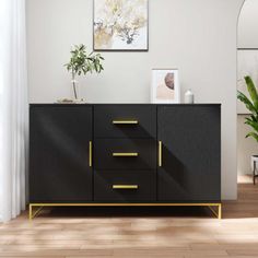 a black and gold sideboard in an empty room with potted plants on the table